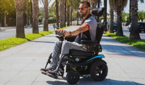 Un hombre joven en una silla de ruedas eléctrica.
