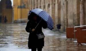 Mujer caminando por la calle bajo la lluvia.