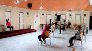 Varias personas hacen ejercicios en un Centro de Participación Activa para mayores.
