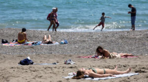 Varios bañistas al sol en una playa de Málaga (Agencia EFE).