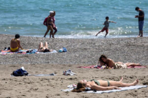 Varios bañistas al sol en una playa de Málaga (Agencia EFE).