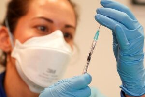 Una profesional sanitaria se dispone a administrar una vacuna.