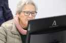 Una mujer consulta la información de Internet a través de la pantalla de un ordenador.